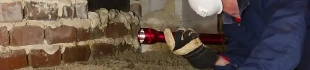 Pest control technician inspecting a crawl space for ant activity and entry points in Omaha, NE