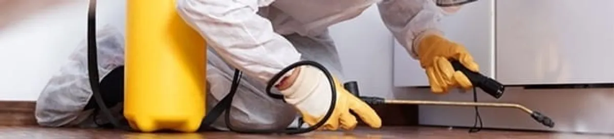 Roach exterminator treating cracks and crevices along kitchen baseboards in Omaha, NE